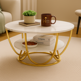 Round coffee table with gold metal frame in a living room setting