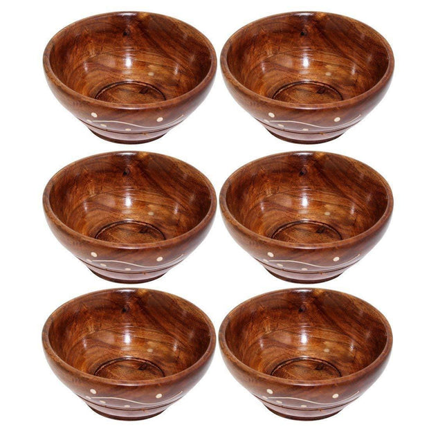 Wooden bowl set with brass carving and tea spoons close up